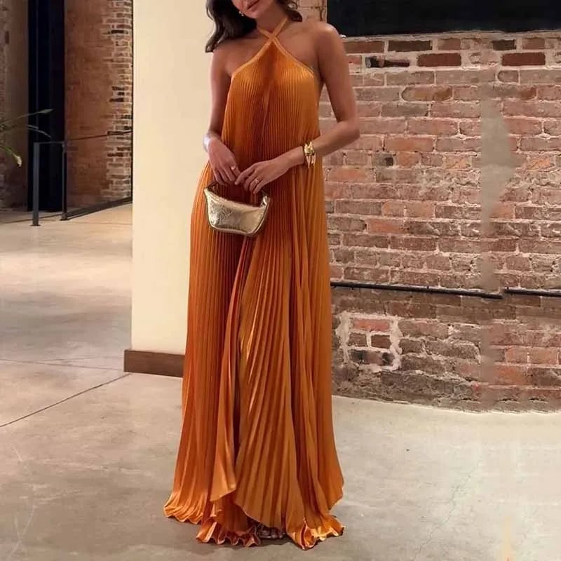 Woman wearing an orange pleated halter maxi dress with a flowing full-length silhouette, front view