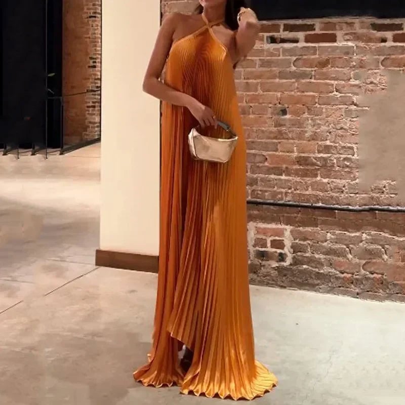 Woman in the orange Carmen halter maxi dress shown from the back, highlighting the open halter tie and draped fabric