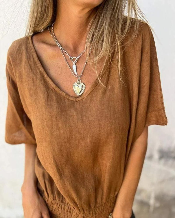 Side view of the flowy relaxed fit summer top in black showing drape and sleeve length