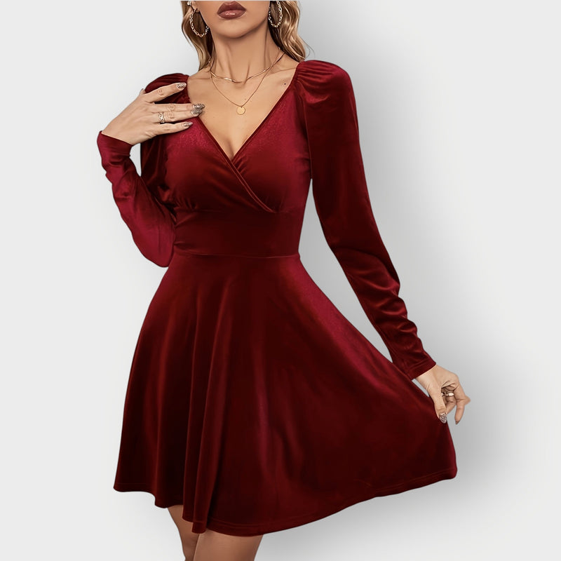 Woman wearing a red velvet skater dress with a fitted bodice and flared skirt, front view