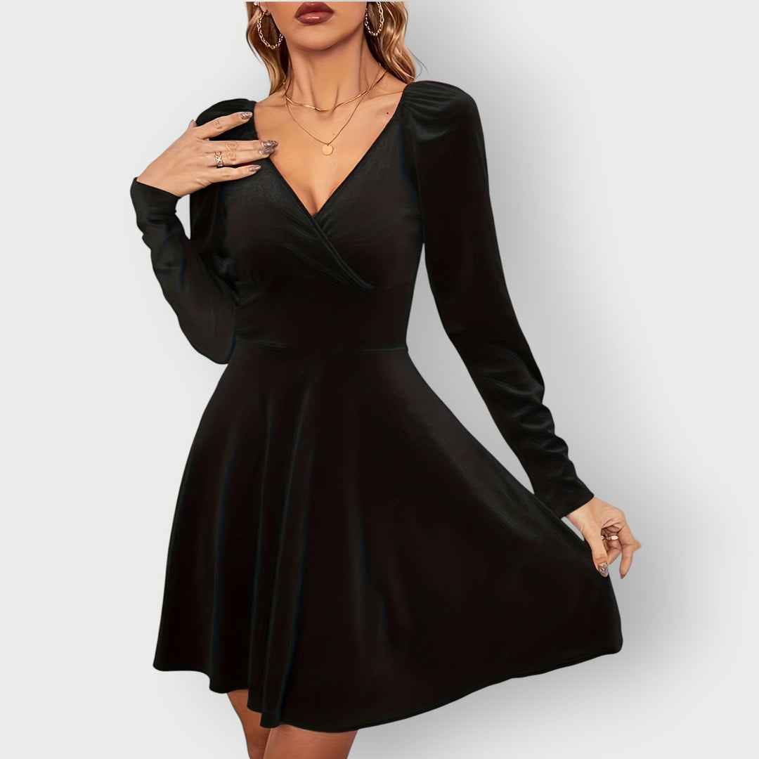 Woman in a green velvet skater dress posed for a festive occasion, front view