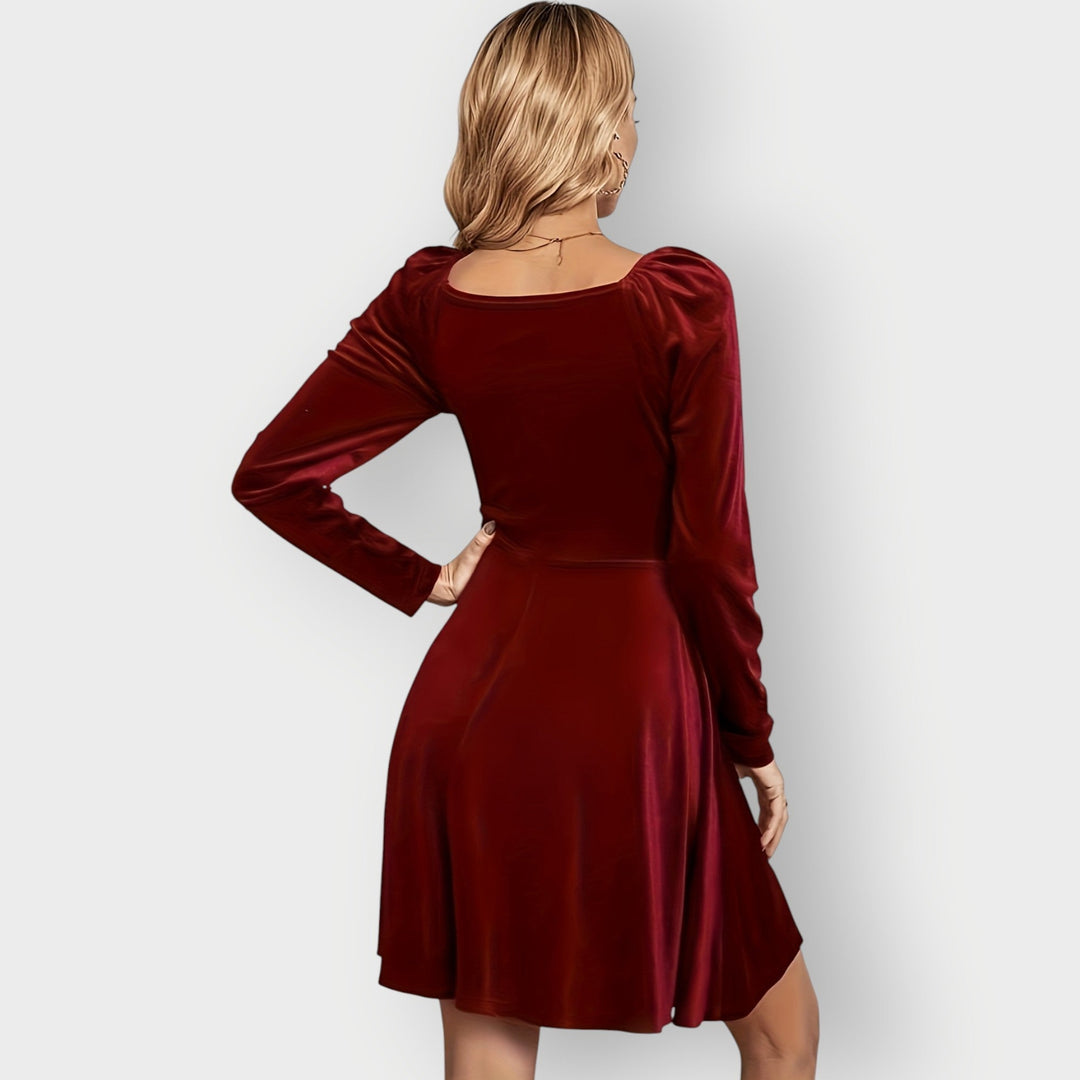 Woman wearing a black velvet skater dress styled for a night out, full-length view