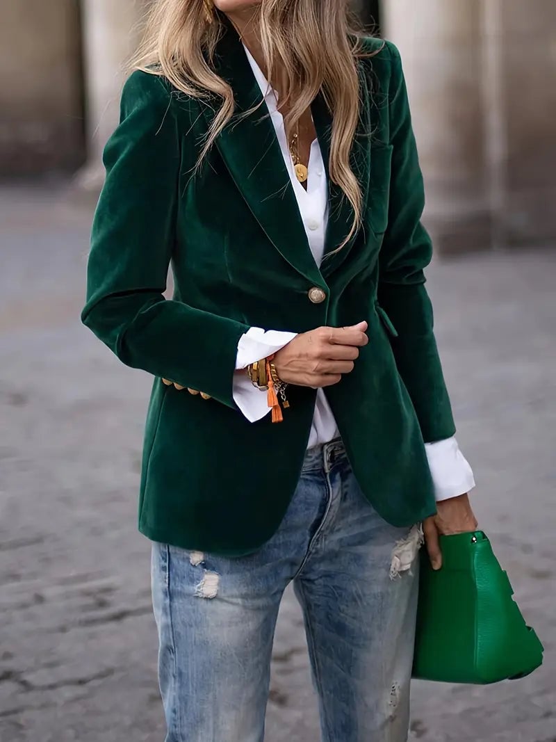 Close-up of plush green velvet blazer fabric showing luxurious texture and drape
