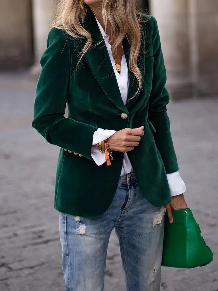 Close-up of plush green velvet blazer fabric showing luxurious texture and drape