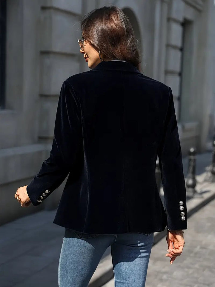 Side profile of a woman in a figure-flattering black velvet blazer