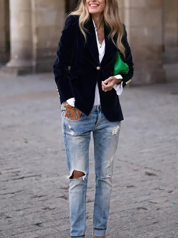 Elegant velvet blazer in deep blue paired with dark jeans and heels