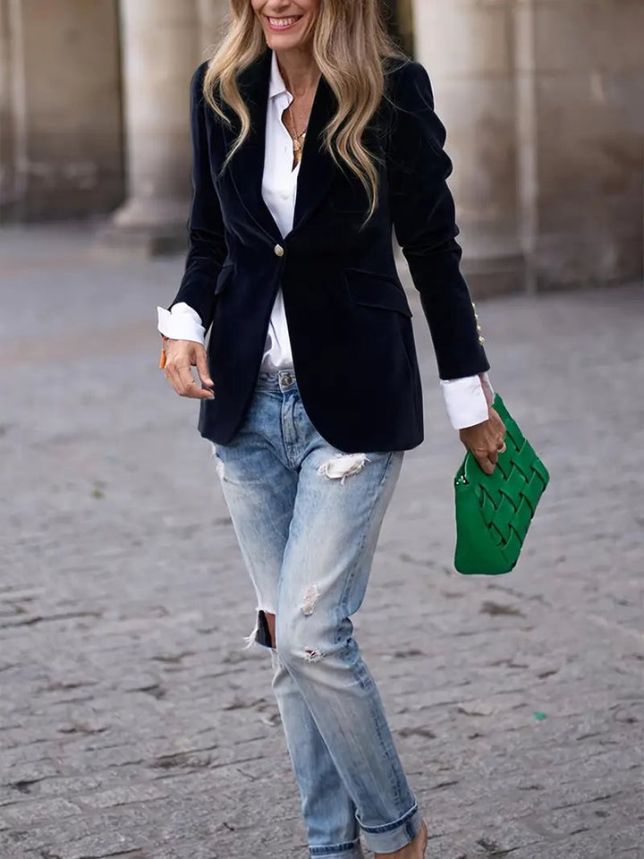 Red velvet blazer worn as a statement layer over a little black dress