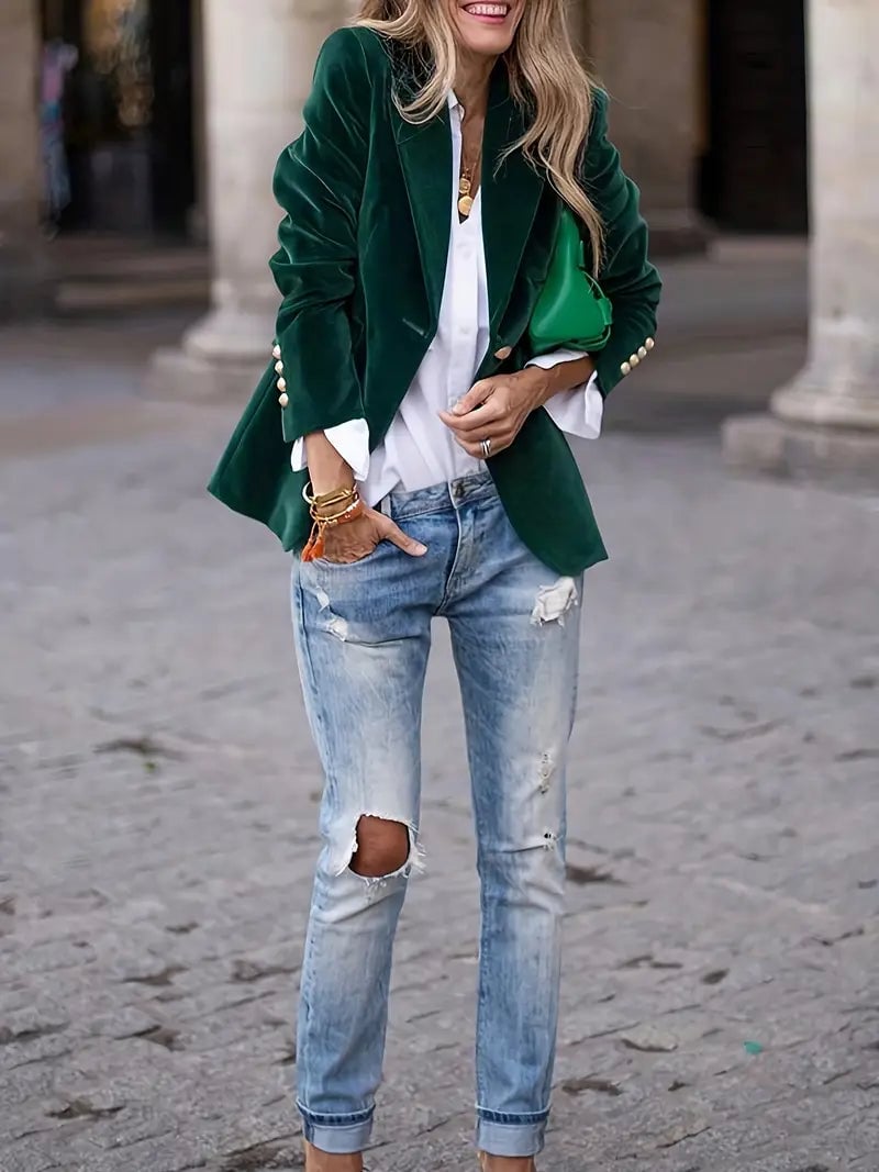 Close-up of velvet blazer sleeve and cuff detail in a deep jewel-toned green