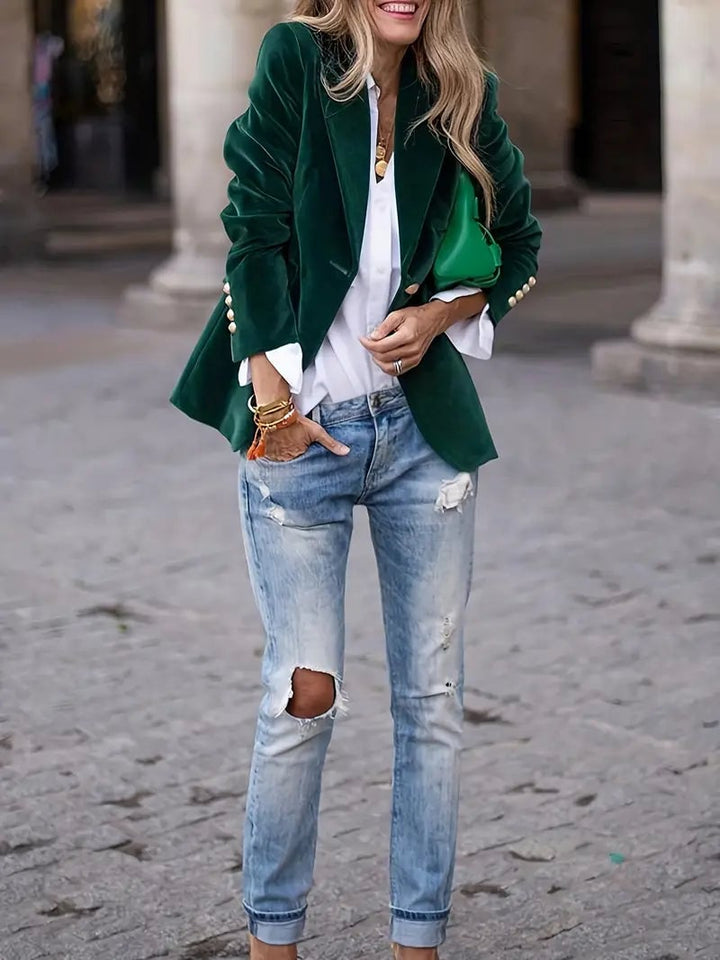 Close-up of velvet blazer sleeve and cuff detail in a deep jewel-toned green