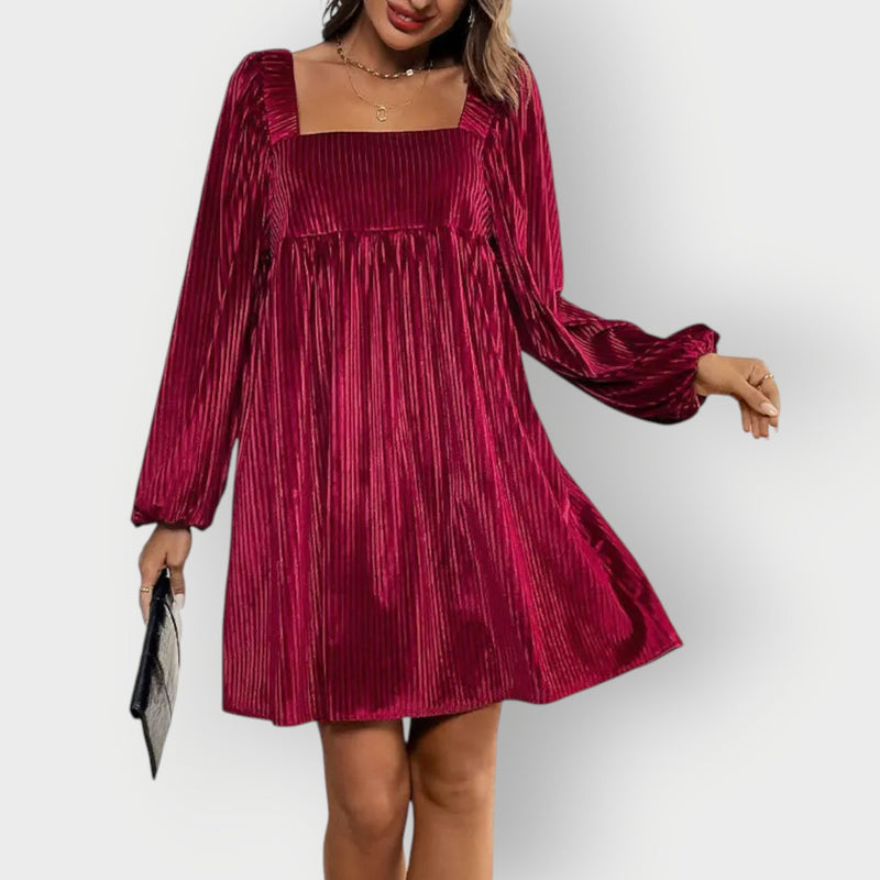 Close-up of plush velvet fabric texture on a chic backless evening dress in wine red