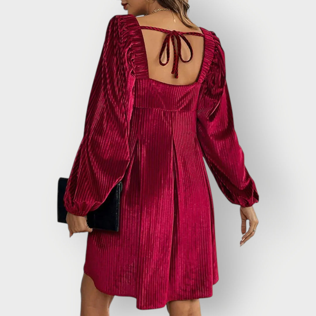 Side profile of a velvet backless dress highlighting the flattering curved silhouette