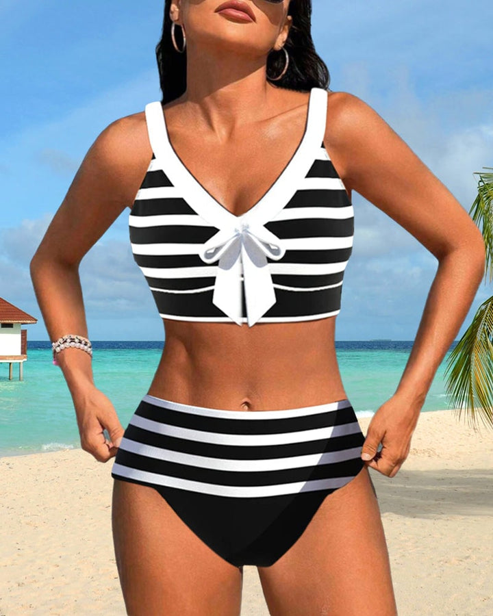 Model wearing Caroline striped bikini set in pink on a sunny beach