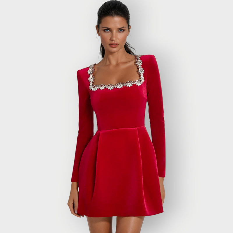 Close-up of red velvet mini dress showing rich fabric texture and structured square neckline