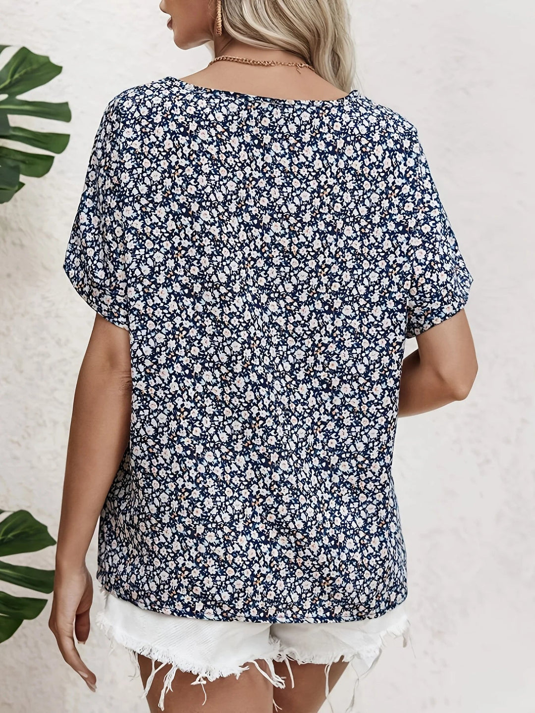 Close-up of navy blue floral blouse showing delicate print and button-up front detail