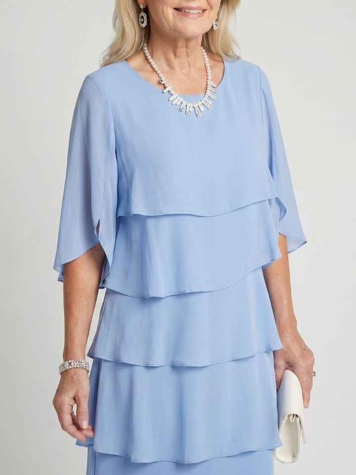 Woman wearing the Cassia tiered midi dress in light blue, full-length front view
