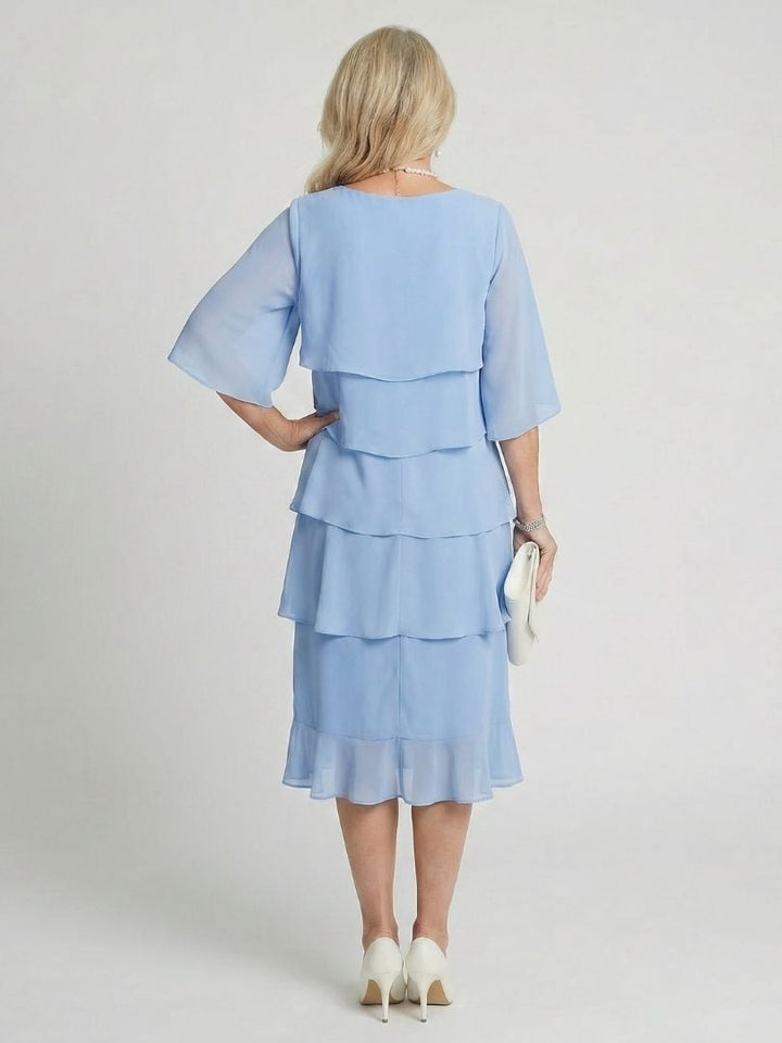 Side profile of the Cassia midi dress in light blue showing elegant flowing layers