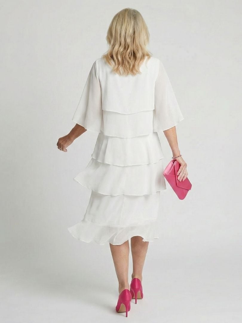Woman wearing the Cassia tiered flutter sleeve midi dress in white, full-length front view