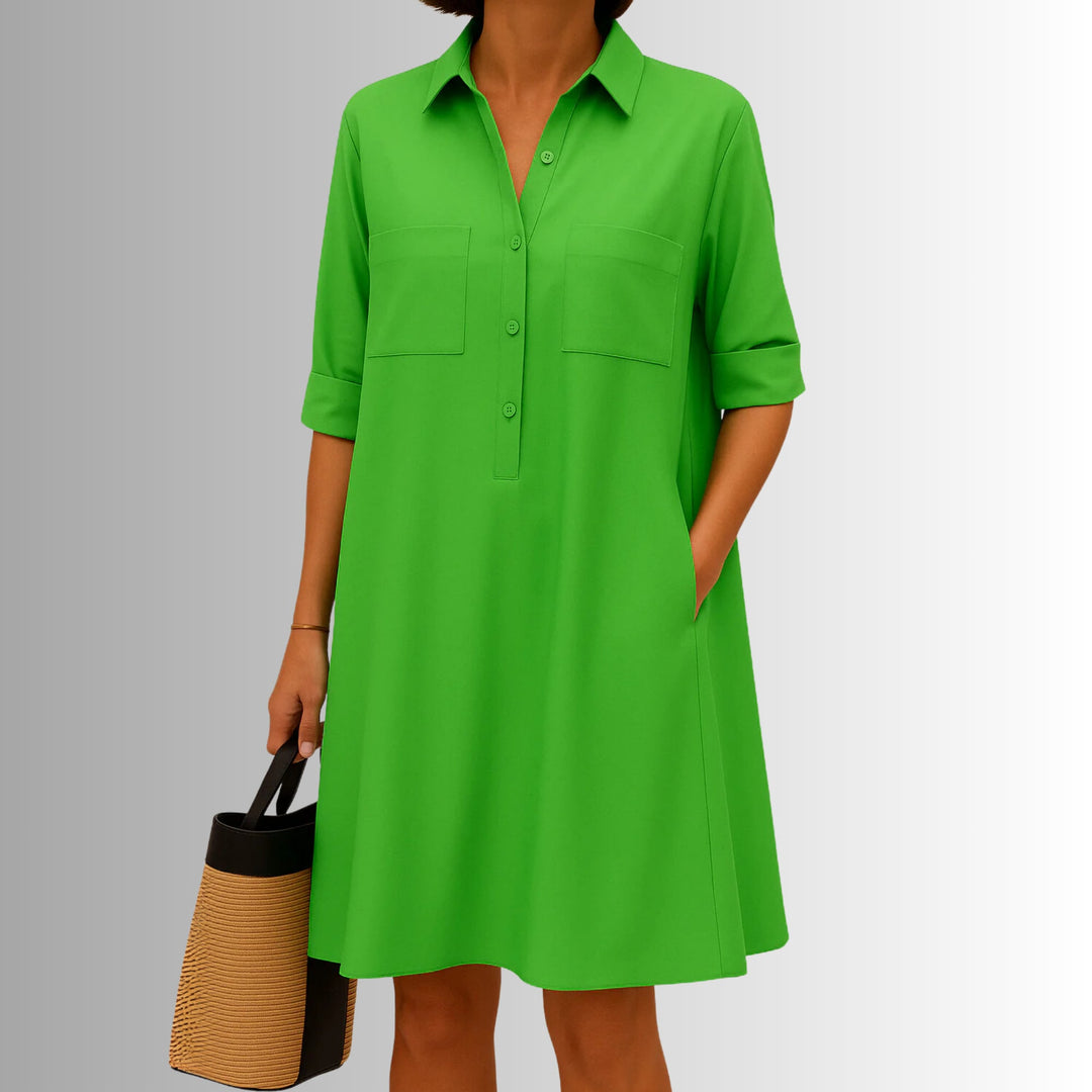 Woman wearing a lightweight A-line button dress with decorative front buttons and a modern collar in green