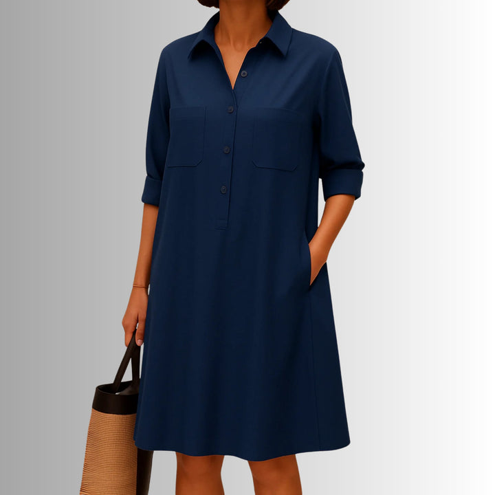 Woman in a lightweight button dress with rolled three-quarter sleeves strolling outdoors in white