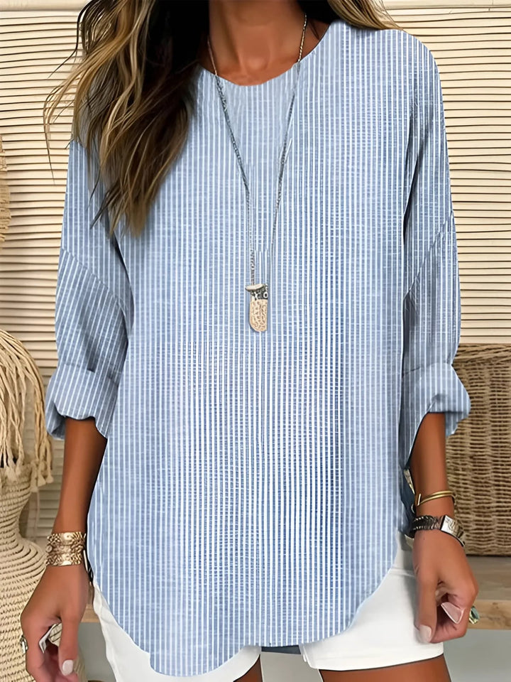 Woman wearing a relaxed-fit striped blouse in a classic stripe pattern, styled casually