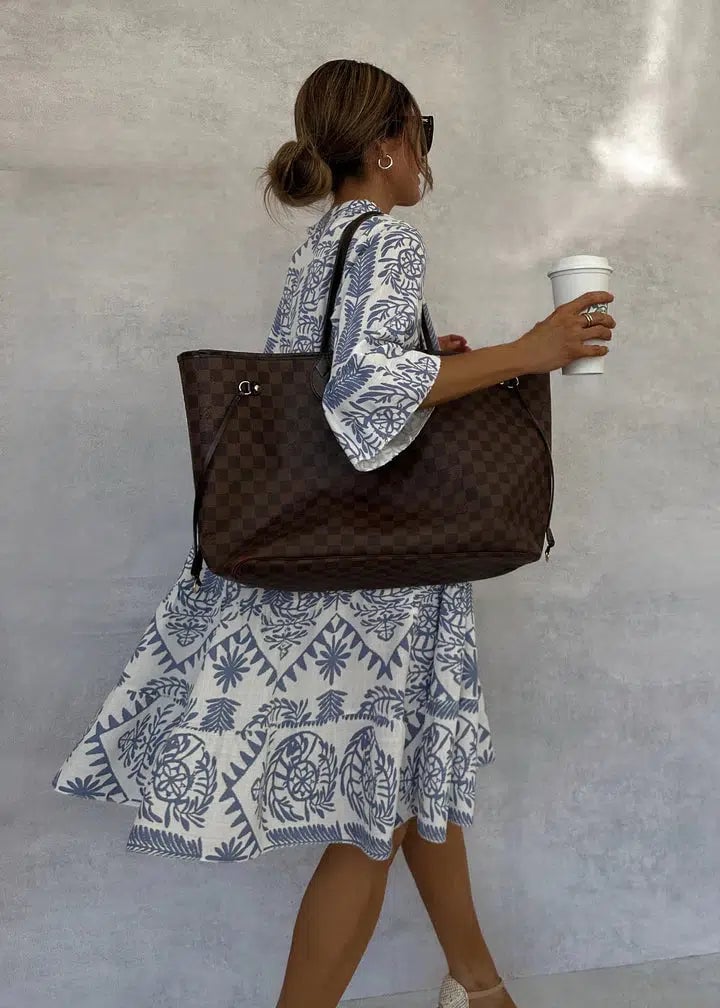 Close-up detail of the Celeste dress showing the intricate blue-and-white botanical tile-inspired block print and button placket