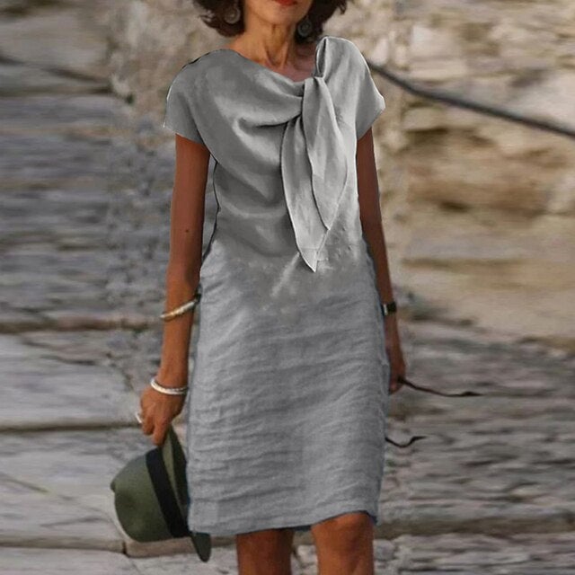 Close-up of the draped bow neckline detail on the Celeste midi dress in gray