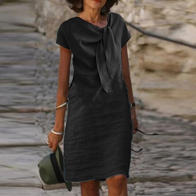 Woman styled in the Celeste midi dress in black paired with heels for a polished warm-weather look