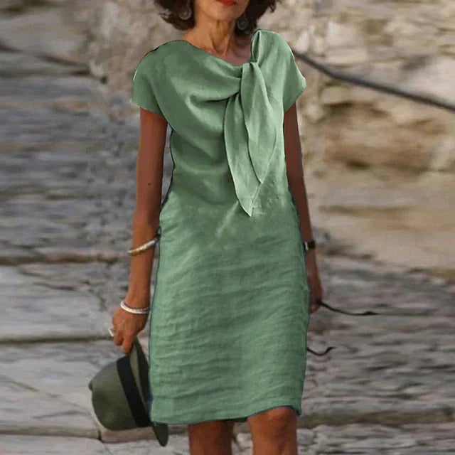 Flat lay of the Celeste bow neck midi dress in green displaying the solid color design and midi-length cut