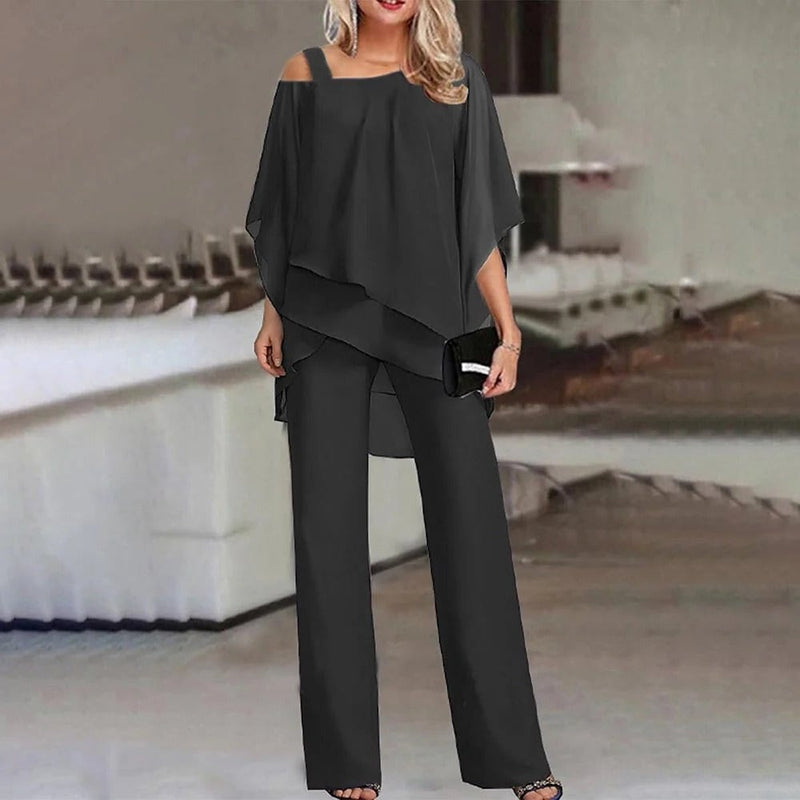 Woman wearing the Celeste black cold shoulder chiffon overlay wide leg jumpsuit at a formal event