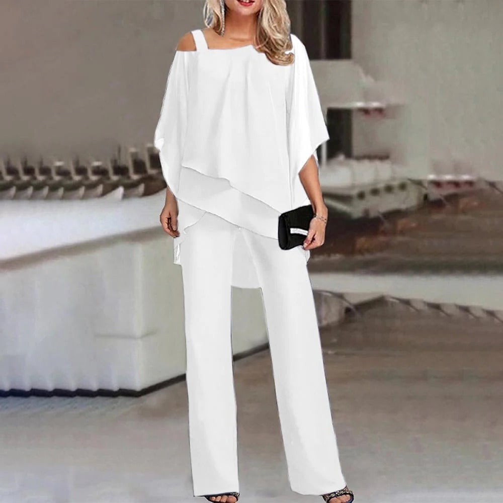 Front view of the Celeste wide leg jumpsuit showing the asymmetric chiffon overlay and open shoulder detail