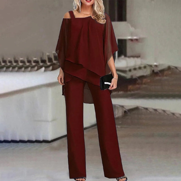 Side view of the Celeste chiffon jumpsuit highlighting the flowing wide leg trousers and draped overlay