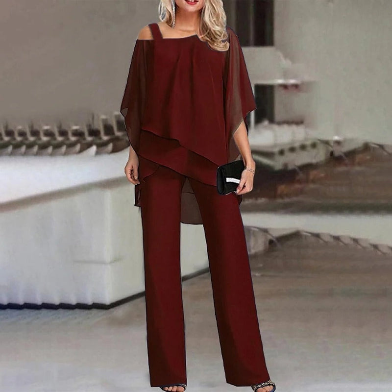 Side view of the Celeste chiffon jumpsuit highlighting the flowing wide leg trousers and draped overlay