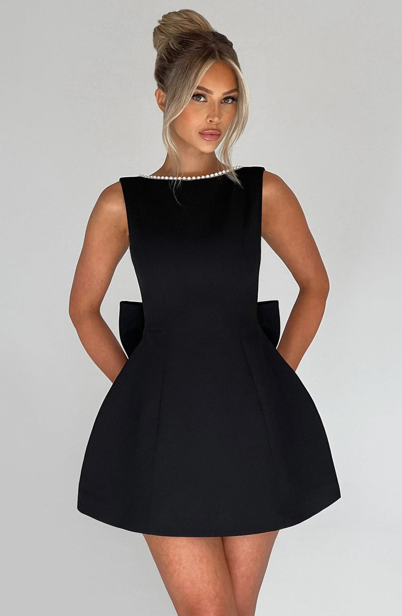 Back view of Celeste mini dress in pink highlighting the dramatic pearl-edged bow detail