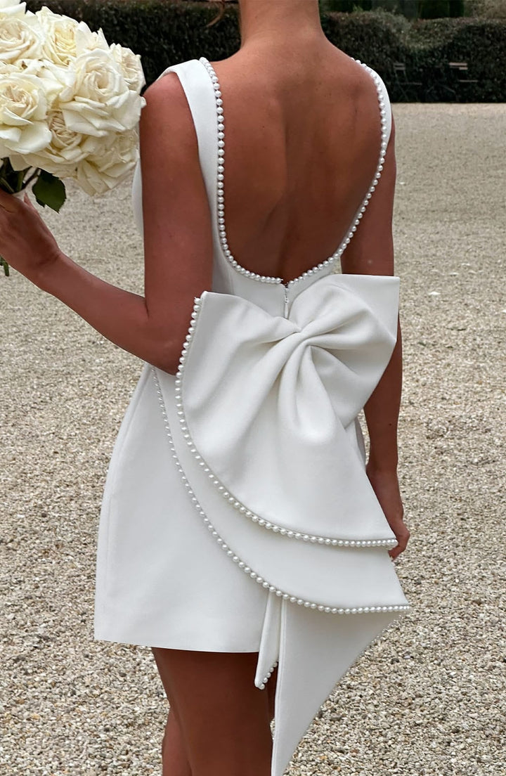 Flat lay of the Celeste pearl trim mini dress showing front and back details