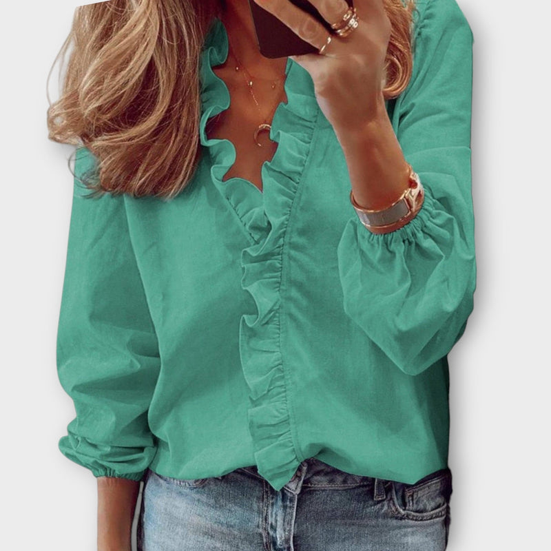 Side view of the Celeste orange long sleeve ruffle blouse showing relaxed tailored fit