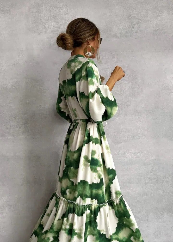 Woman wearing a green-and-white tie-dye belted long sleeve tiered maxi dress with a flowing ruffle hem