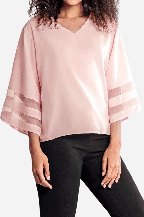 Side view of the Celeste white cropped bell sleeve blouse showing the relaxed fit and flowing sleeve silhouette