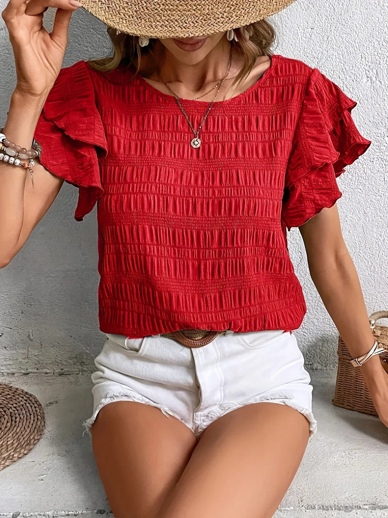 Model wearing a light and breezy ruffle sleeve blouse in red with subtle pleats and a flowy silhouette