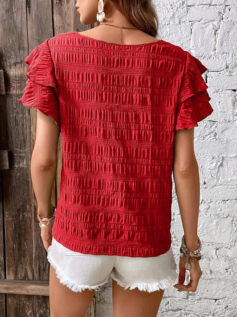 Close-up of ruffle sleeve detail on a breezy women's blouse in malachite blue