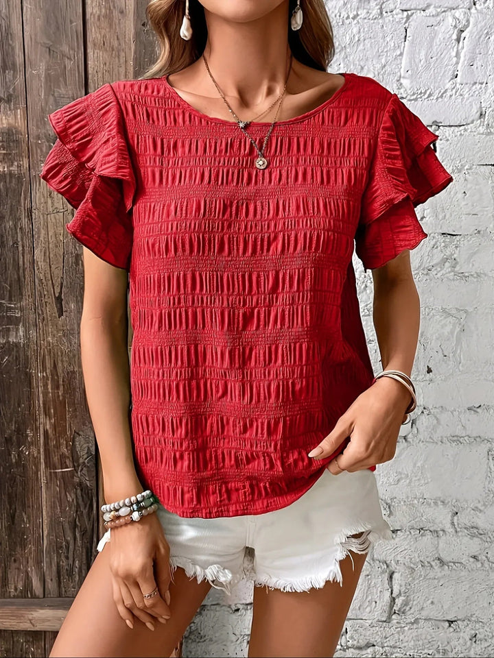 Back view of light breathable ruffle blouse in navy blue with flowing hem