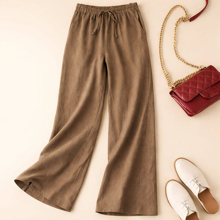 Model wearing relaxed drawstring pants in a neutral color, styled casually for warm weather