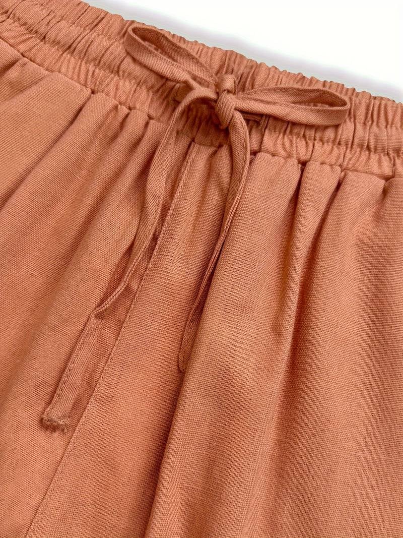 Model wearing drawstring pants in salmon color for a warm-weather casual look