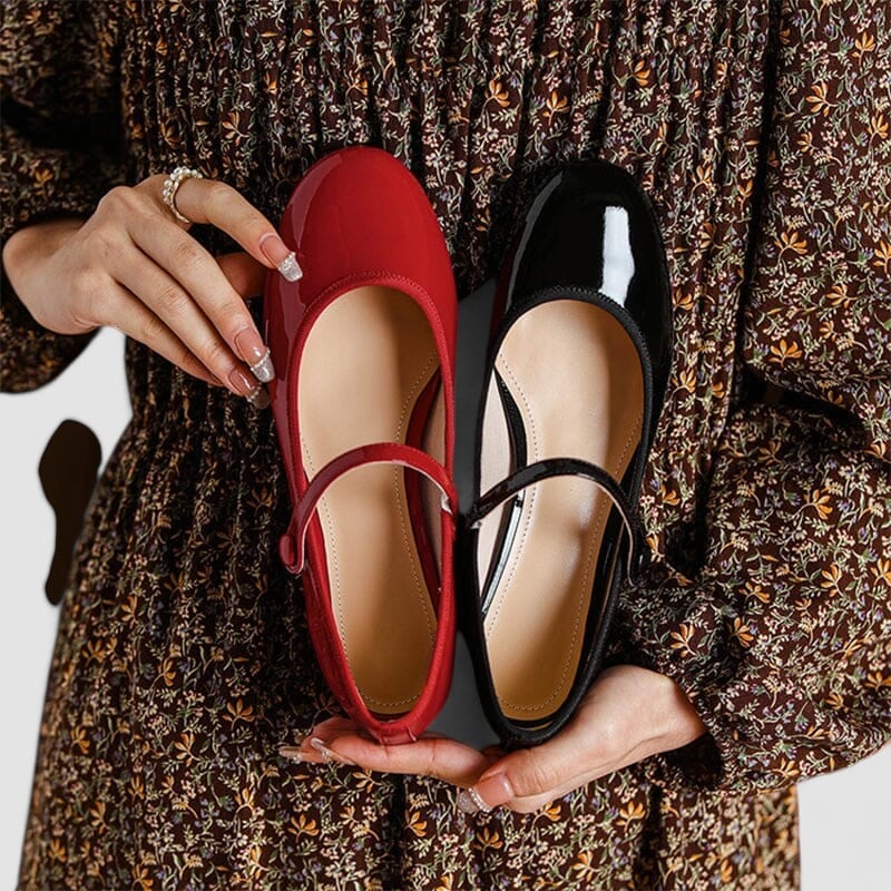 Pair of classic elegant shoes in red arranged neatly on a clean white surface