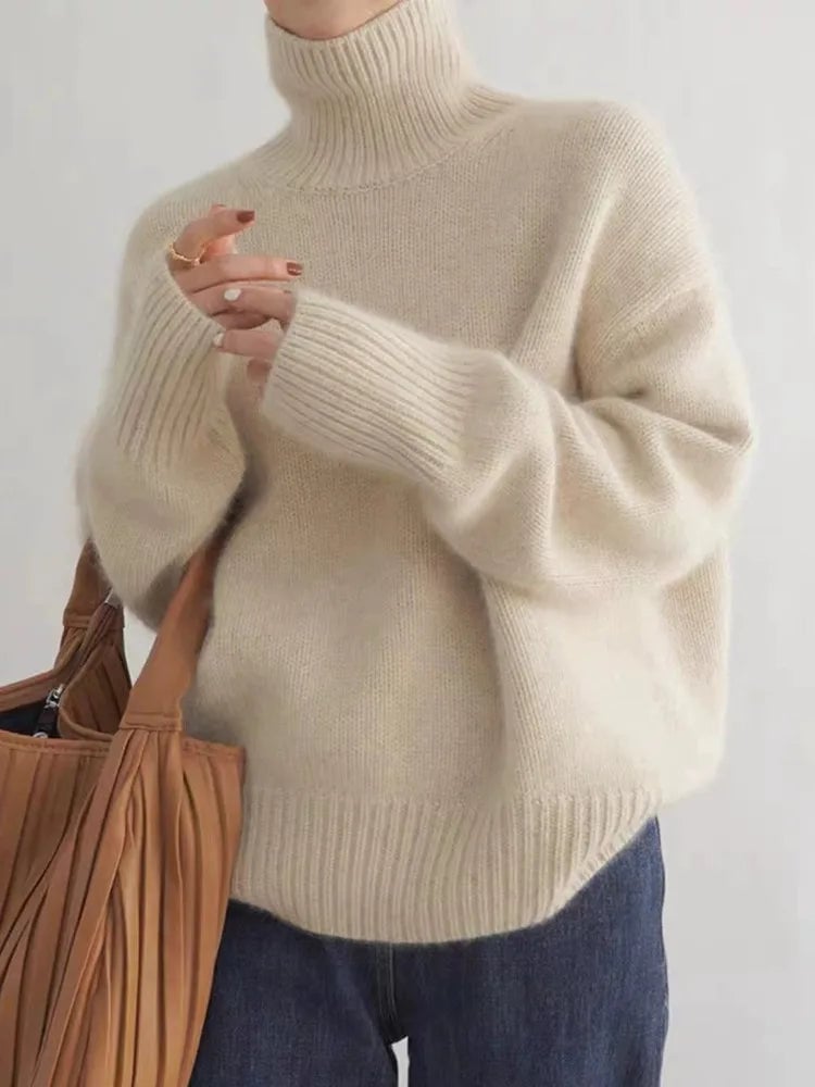 Woman wearing a beige high collar knit sweater with a relaxed, flattering fit