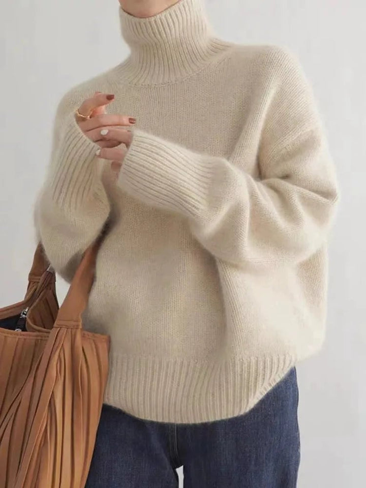 Woman wearing a beige high collar knit sweater with a relaxed, flattering fit