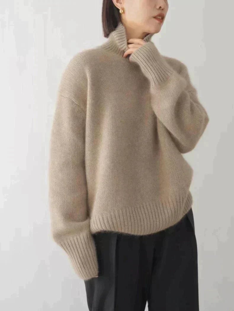 Front view of a woman in a khaki high collar sweater styled with trousers