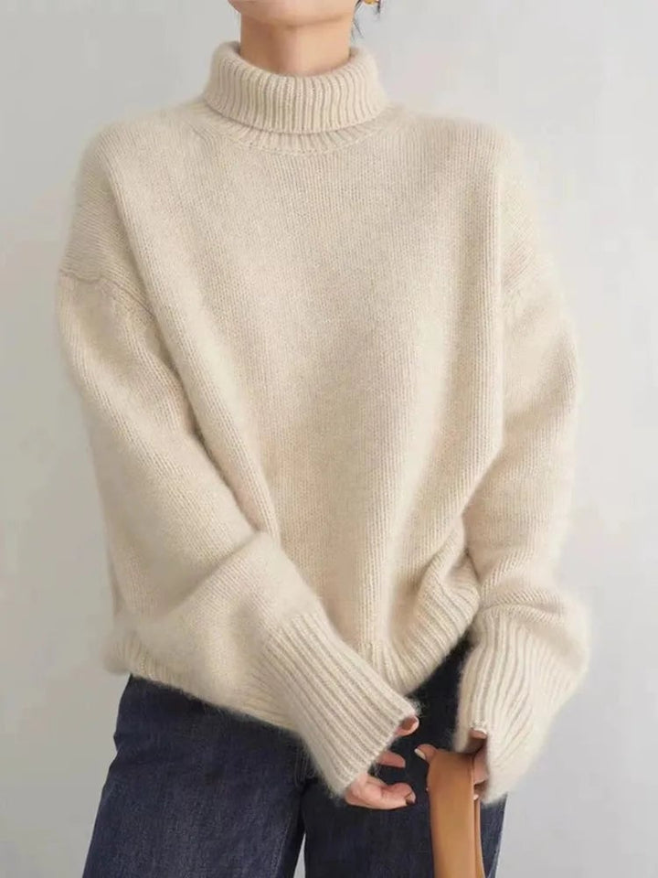 Woman layering a grey high collar sweater under a longline coat for a chic fall look