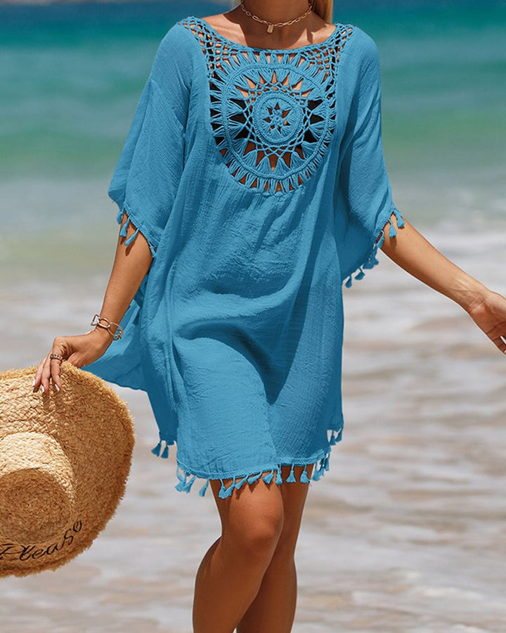 Model in black boho beach cover-up with crochet detail styled over a swimsuit poolside