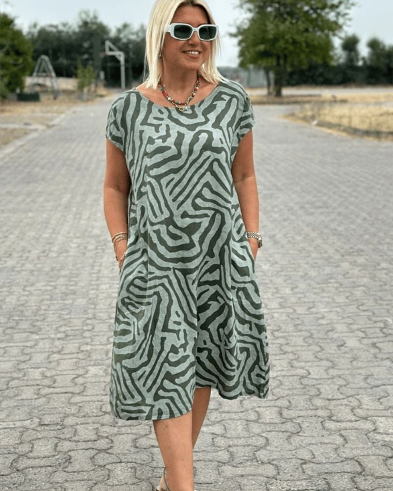 Woman wearing a lightweight printed summer dress with a round neckline in a relaxed outdoor setting