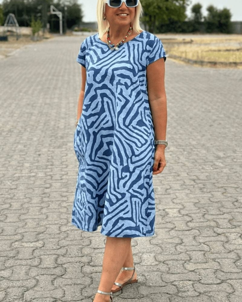 Model wearing a printed summer dress styled with sandals for a casual daytime look